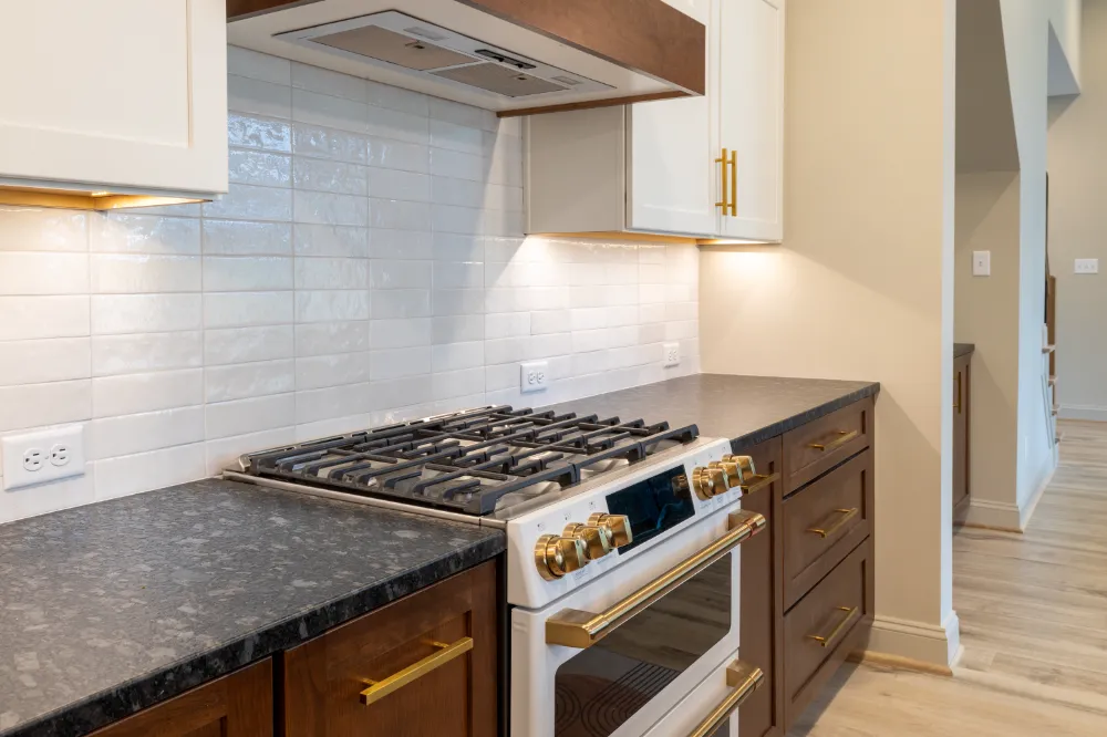 Kitchen with white upper cabinets, wood lower cabinets, and a gas range